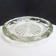 Vintage round clear glass decorative cigar and cigarette ashtray with a starburst design in the center and a criscross X pattern on the side. Main View