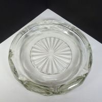 Vintage round clear glass decorative cigar and cigarette ashtray with a starburst design in the center and a criscross X pattern on the side. Top View - Click to enlarge