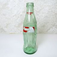 1993 Seasons Greetings 8 oz Coca Cola Classic Bottle. Santa's silhouette and holly sprigs in white framed in red: Front View