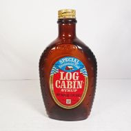 1976 Eagle Log Cabin bicentennial brown glass pancake syrup bottle. Paper label, ribbed sides, metal cap: Front View