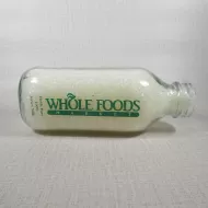 Whole Foods Market Floresville Texas StanPac clear glass square one quart milk bottle with green graphics: Front Flat
