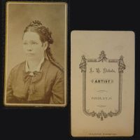 Antique CDV Carte De Visite: Woman from the waist area up with tight ringlet curls and a straight line smile: Front and Back View - Click to enlarge