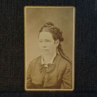 Antique CDV Carte De Visite: Woman from the waist area up with tight ringlet curls and a straight line smile: Front View - Click to enlarge