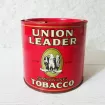 Union Leader vintage 14 oz. empty round tobacco tin with key. Black, white and gold graphics on red background: Front