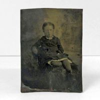 Antique Tintype Photo: Little girl with crossed legs leaning back in a chair: Front View - Click to enlarge