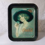 Metal Coke serving tray with wall hanger. Gibson Girl with big hat lifting a small glass of Coca Cola: Top View