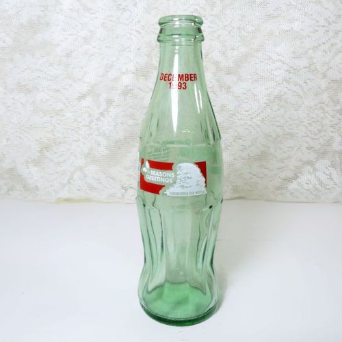 1993 Seasons Greetings 8 oz Coca Cola Classic Bottle. Santa's silhouette and holly sprigs in white framed in red: Front View
