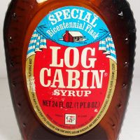 1976 Eagle Log Cabin bicentennial brown glass pancake syrup bottle. Paper label, ribbed sides, metal cap: Label View - Click to enlarge