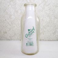 Cloverleaf Dairy in Sandusky, Ohio quart ACL glass milk bottle. Graphics show a baby laying in a crib holding a baby bottle: Front View