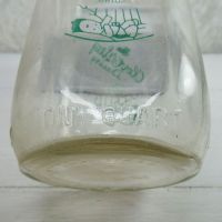 Cloverleaf Dairy in Sandusky, Ohio quart ACL glass milk bottle. Graphics show a baby laying in a crib holding a baby bottle: ONE QUART View - Click to enlarge