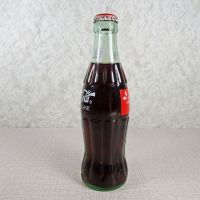 1991 Seasons Greetings full Classic Coke bottle. Santa’s face in white and black on a red background: Right - Click to enlarge