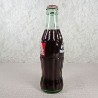 1991 Seasons Greetings full Classic Coke bottle. Santa’s face in white and black on a red background: Left - Click to enlarge