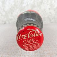 1991 Seasons Greetings full Classic Coke bottle. Santa’s face in white and black on a red background: Top - Click to enlarge