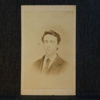 Antique CDV Carte De Visite: Clean shaven man from the shoulder area up sporting a long knot tie with tie pin and jacket: Front View - Click to enlarge