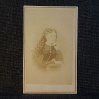 Antique CDV Carte De Visite: Woman from the waist area up with long curly hair, head resting on one hand: Front View - Click to enlarge