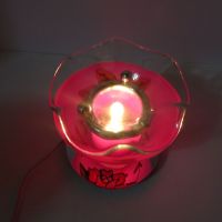 Electric scented oil tart warmer featuring a raised etched rose design against a deep pink background: Top On View - Click to enlarge