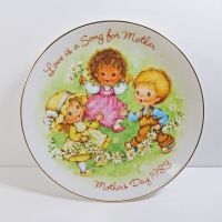 1983 Mother's Day Avon collector plate titled Love is a Song showing three children frolicking in a field of flowers: Top View - Click to enlarge