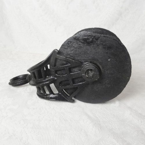 Vintage wood pulley with 5-1/2 inch wood wheel and metal cast iron case or frame with swivel eye. All painted black: Left Side View