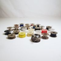 Lot of 25 various vintage sewing machine bobbins and 1 bobbin case. Some with thread: Front View - Click to enlarge