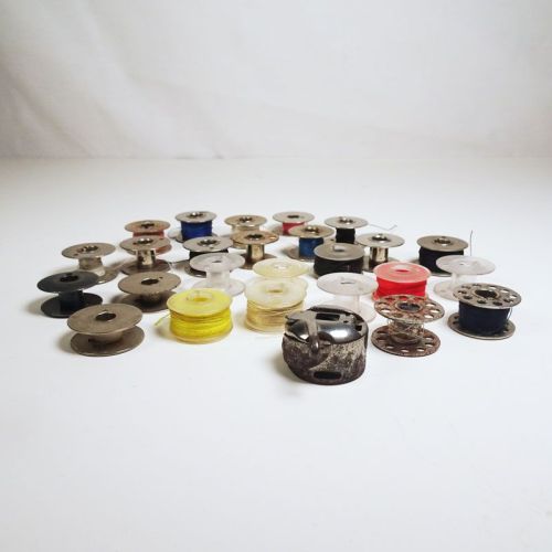 Lot of 25 various vintage sewing machine bobbins and 1 bobbin case. Some with thread: Front View