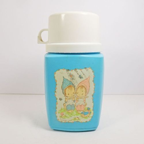 1975 Precious Moments 8 oz. thermos with blue plastic body and cream colored top that doubles as a cup: Front View