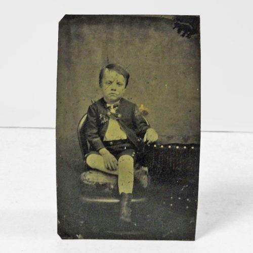 Antique Tintype Photo: Bored boy with a blank stare sitting in a chair with his legs crossed: Front View