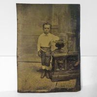 Antique Tintype Photo: Sad looking boy standing with one arm leaning on a short post or pillar: Front View - Click to enlarge