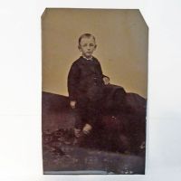 Antique Tintype Photo: Boy with his feet crossed wearing striped socks, standing on a flowered rug: Front View - Click to enlarge