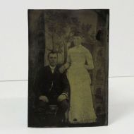 Antique Tintype Photo: Wedding Portrait Man sitting and a woman standing at his side wearing a white dress: Front View