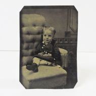 Antique Tintype Photo: Smiling little girl sitting in a too big buttoned back chair: Front View