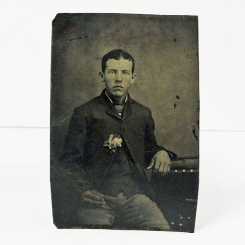 Antique Tintype Photo: Man sitting, with a boutonniere in his jacket. The hand resting in his lap is very dark: Front View