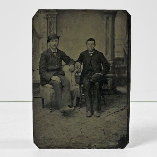 Antique Tintype Photo: Two men sitting, one man wearing his bowler hat, the other man holding his similar hat on his lap: Front View