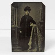 Antique Tintype Photo: Woman standing, leaning her arm on something draped with a blanket wearing a fancy hat: Front View