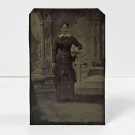 Antique Tintype Photo: Woman arm on a highback button chair wearing a tight fitting long sleeve dress with wide collar and bow: Front View